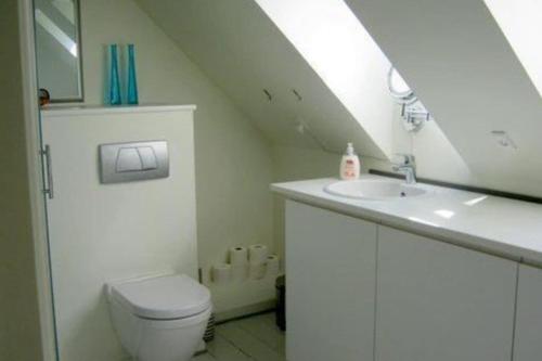 a white bathroom with a sink and a toilet at Skøn lejlighed i Ærøskøbing. in Ærøskøbing