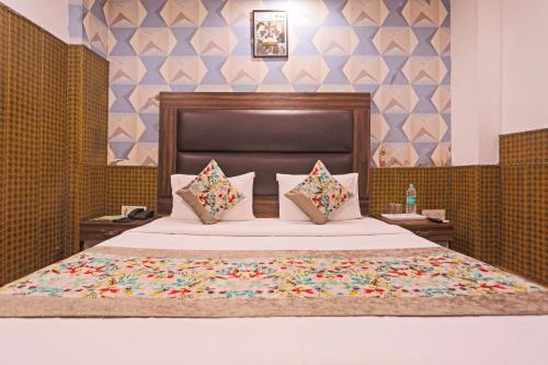 Mayda Residency By Mayda Hospitality Pvt. Ltd. في نيودلهي: غرفة نوم بسرير كبير مع وسادتين