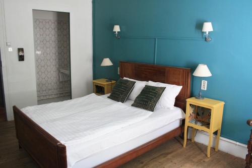 een slaapkamer met een groot bed met blauwe muren bij Le Therminus chambres d hôtes in Rennes-les-Bains