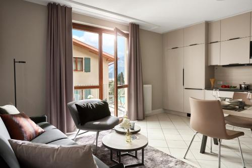a living room with a couch and chairs and a kitchen at June Stay Lake Garda in Brenzone sul Garda