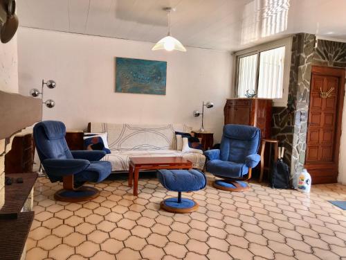 a living room with blue chairs and a bed at Maison 90 m2, 5 min du Port, 15 min des Criques à Pied in Port-Vendres