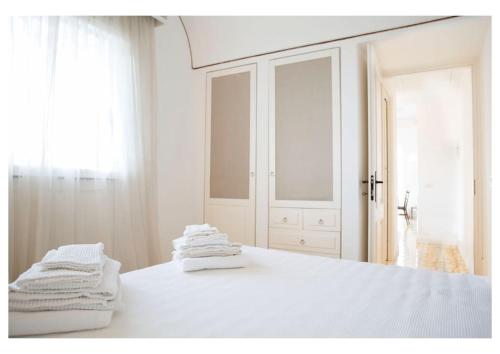 a white bedroom with white towels on a bed at Capri centre house with jacuzzi in Capri