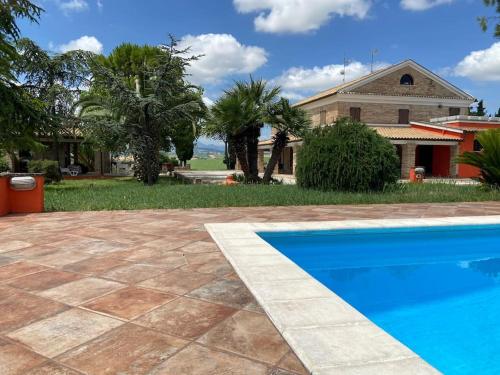 a blue swimming pool in front of a house at Casale Monte Amato in Tornasano