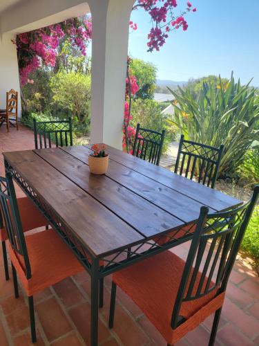 una mesa de madera y sillas en un patio en Feliz Apartments, en São Bartolomeu de Messines