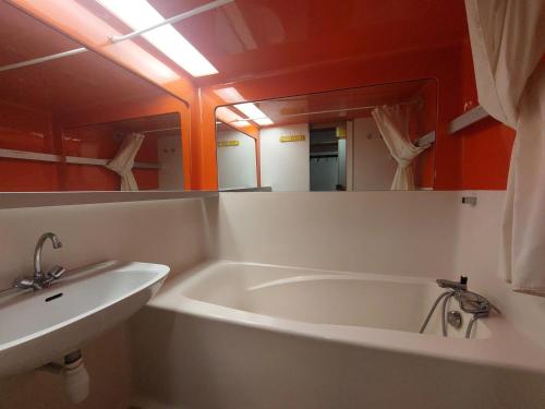 une salle de bain avec une baignoire et un lavabo dans l'établissement Duplex 2 pièces à Arc 1800 avec WiFi, cuisine équipée et casier à ski - FR-1-411-191, à Arc 1800