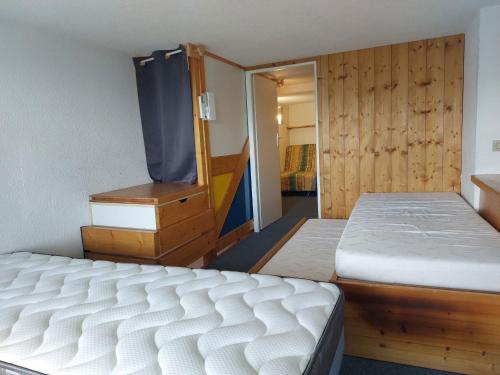 une chambre avec deux lits et une commode dans l'établissement Duplex 2 pièces à Arc 1800 avec WiFi, cuisine équipée et casier à ski - FR-1-411-191, à Arc 1800