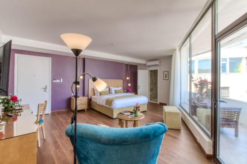 une chambre d'hôtel avec un lit et une chaise bleue dans l'établissement The Liwan Hotel, à Amman