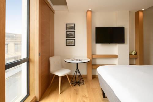 a bedroom with a bed and a table and a tv at Market Street hotel in Edinburgh