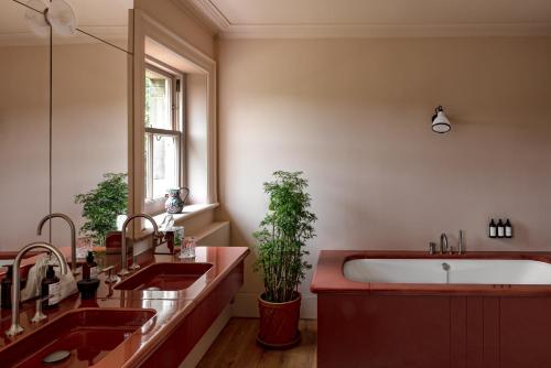 a bathroom with two sinks and a bath tub at Cowley Manor Experimental in Cheltenham