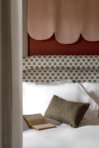 a bed with a headboard and a pillow on it at Cowley Manor Experimental in Cheltenham