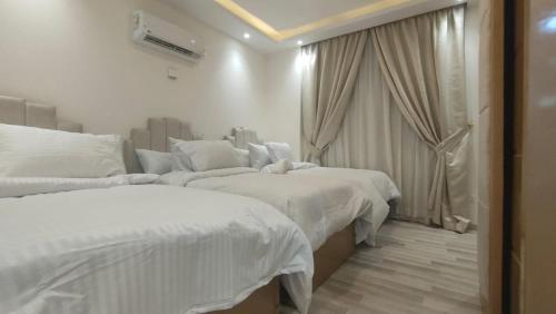 um quarto de hotel com duas camas e uma janela em التجمع الخامس no Cairo