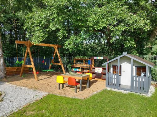 een speeltuin met een tafel en een schommel bij Master Camp Santoczno in Santoczno