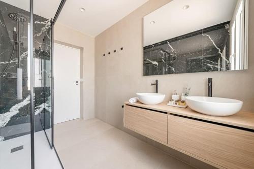 a bathroom with two sinks and a shower at Chalet de lujo 'LA CASA DE INÉS' in Alcalá de Henares