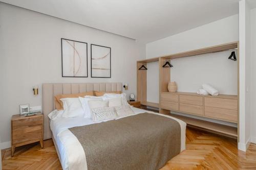 um quarto branco com uma cama grande e uma janela em Chalet de lujo 'LA CASA DE INÉS' em Alcalá de Henares