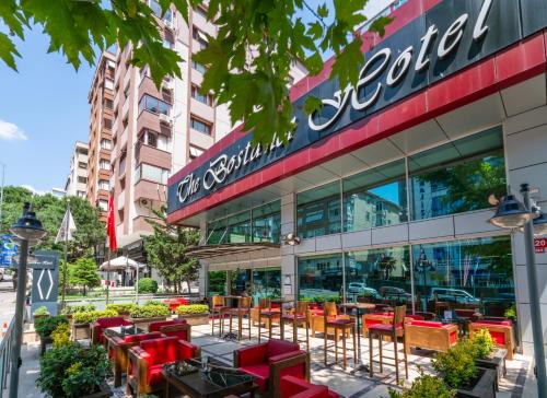 a restaurant with red chairs and tables in front of a building at The Bostancı Otel in Istanbul