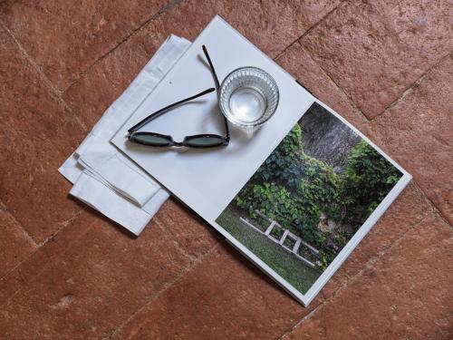 a pair of sunglasses sitting on top of a magazine at Villa di Piazzano - Small Luxury Hotels of the World in Cortona