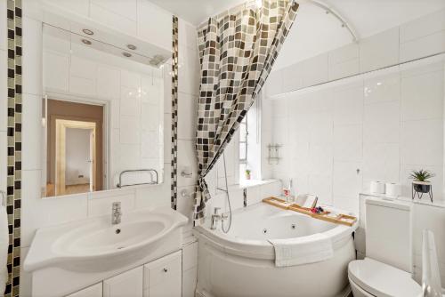 La salle de bains blanche est pourvue d'un lavabo, d'une baignoire et de toilettes. dans l'établissement One Bedroom Apartment By Dream Key Properties Short Lets & Long Lets Chelsea with Free Wi-fi and Netflix, à Londres