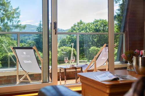 a room with a window with two chairs and a table at Macdonald Plas Talgarth Resort in Aberdyfi