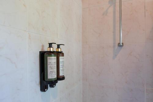 een badkamer met twee zeepflessen aan de muur bij Quinta da Graca- Complexo Turistico in Resende