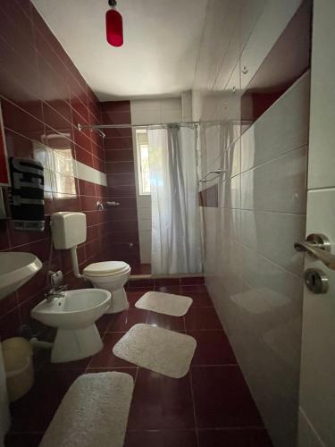 a bathroom with a toilet and a sink at Vacation Home Dibra in Velipojë