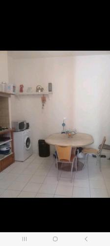 une cuisine avec une table et des chaises et un micro-ondes dans l'établissement Appartement en plein cœur du centre historique, à Montpellier