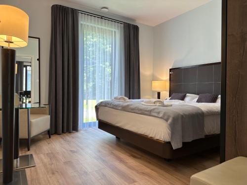 a bedroom with a large bed and a large window at Domki Zdrojowe in Polanica-Zdrój