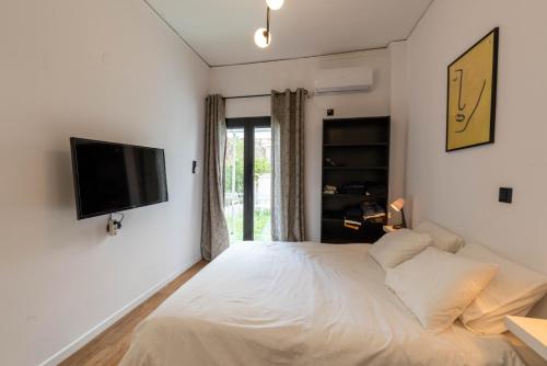 een slaapkamer met een bed en een flatscreen-tv bij Neos_kosmos_house in Athene