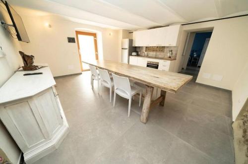 a large kitchen with a wooden table and chairs at Borgo degli Artisti boutique rooms in Serricciolo