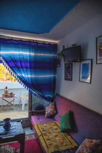 - un salon avec un canapé violet et une fenêtre dans l'établissement Casa Mar, à Chefchaouen