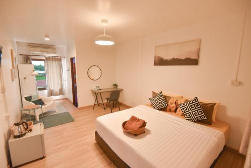 P.U. Inn Resort في فرا ناخون سي أيوتثايا: غرفة نوم مع سرير وغرفة معيشة
