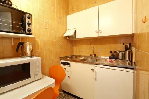 a small kitchen with a sink and a microwave at Hotel Tor in Geneva