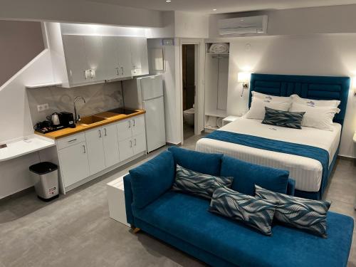 1 dormitorio con 1 cama y 1 sofá azul en Ocean Blue Suites, en Ierissos