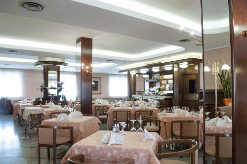 un comedor lleno de mesas y sillas con manteles rosados en Le Gronde, en Cava Manara