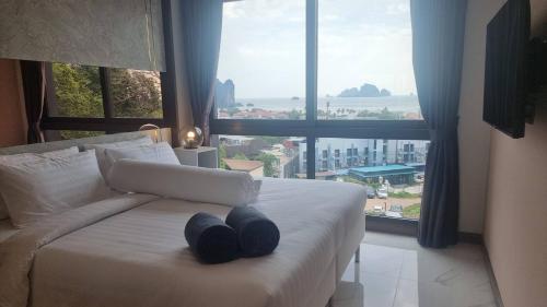 a bedroom with a white bed with two blue pillows at Bo304-Panorama Seaview 1 Bedroom at Ao Nang Beach in Ao Nang Beach