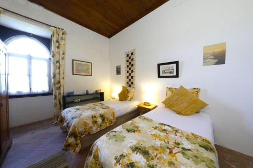 a bedroom with two beds and a window at Vale Formoso-authentic Farmhouse &pool-tavira 3km in Tavira