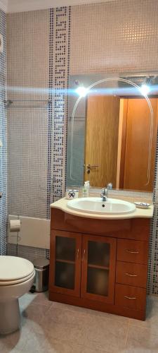 La salle de bains est pourvue d'un lavabo, de toilettes et d'un miroir. dans l'établissement Tavira Pimpão - Sea View Flat, à Tavira