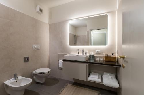 a bathroom with a sink and a toilet and a mirror at June Stay Lake Garda in Brenzone sul Garda