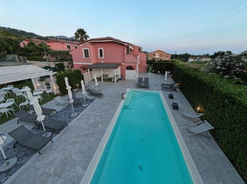a swimming pool with chairs and a house at B&B Villa Fabrizia in Diamante
