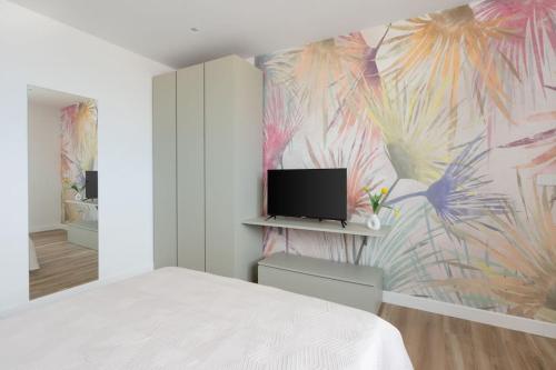 ein Schlafzimmer mit einem Bett und einem TV an der Wand in der Unterkunft Attico 70 - Puteoli Apartament in Pozzuoli