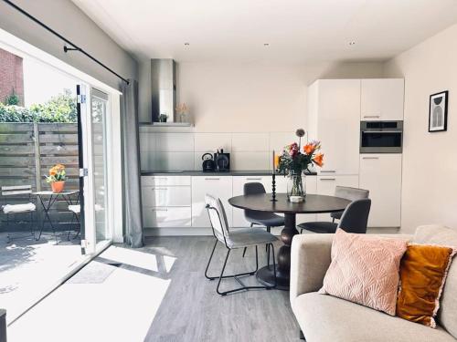 a kitchen and living room with a table and chairs at The Bank's Lodge by ZILT in Limmen