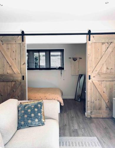 a living room with a bed and a sliding barn door at The Bank's Lodge by ZILT in Limmen