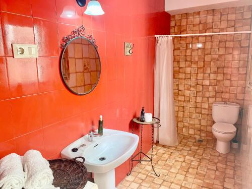 ein Badezimmer mit einem Waschbecken, einem WC und einem Spiegel in der Unterkunft Casa El Cerro in Villacarrillo