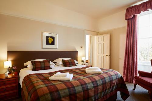 a bedroom with a bed with two towels on it at Macdonald Plas Talgarth Resort in Aberdyfi