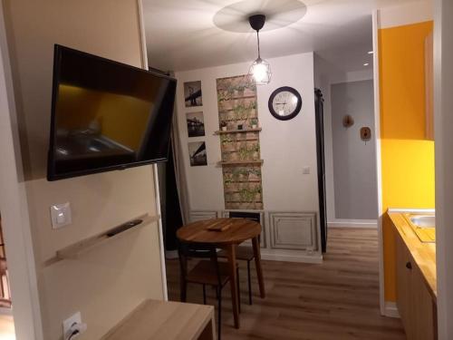 Una cocina con una mesa y un reloj en la pared. en La Grelauderie 6, en Saintes