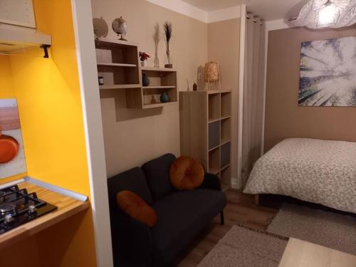Una pequeña habitación con una cama y una silla dentro. en La Grelauderie 6, en Saintes
