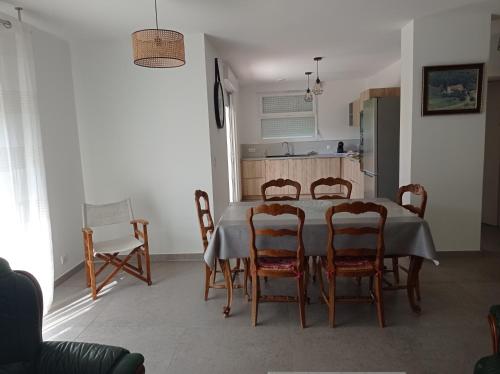 une cuisine et une salle à manger avec une table et des chaises dans l'établissement LA MAISON DE PAPOU La Vigne A NANS LES PINS 83860, à Nans-les-Pins