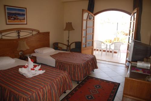 a hotel room with two beds and a television at شالية شرم الشيخ in Sharm El Sheikh