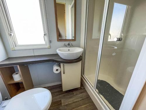 a bathroom with a sink and a shower and a toilet at Lovely Caravan With Decking At Sand Le Mere Park In Yorkshire Ref 71032tv in Tunstall