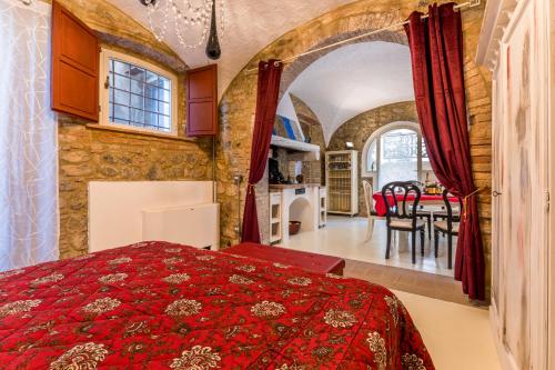 Lajatico Domus في لاياتيكو: غرفة نوم بسرير احمر وغرفة طعام