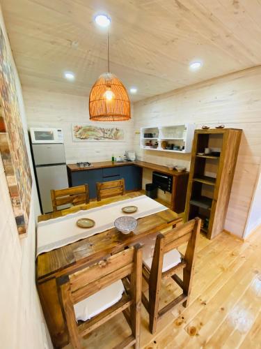 a kitchen with a table and chairs in a cabin at forest house - a pasos del mar in Pichilemu